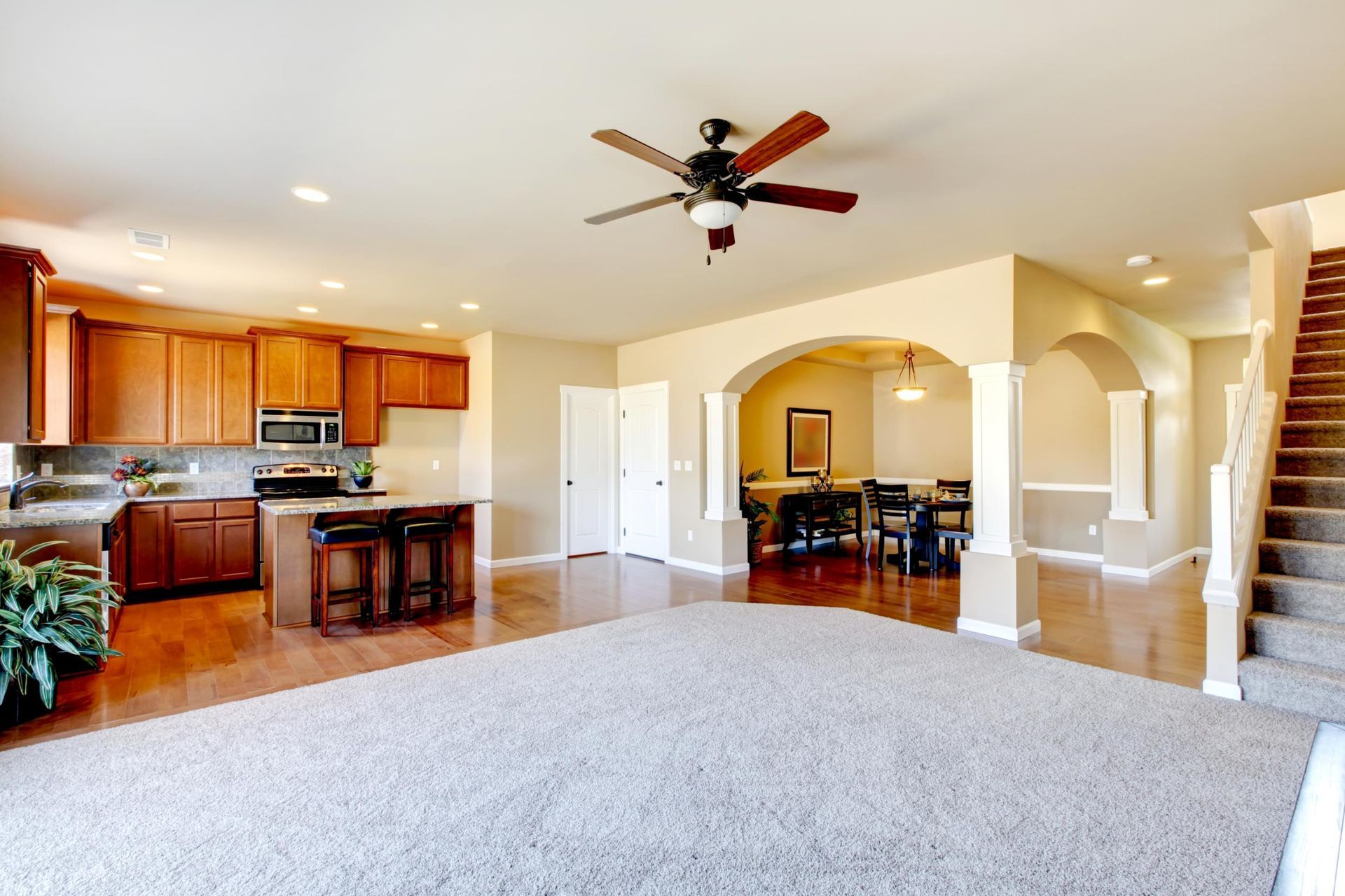 A living room filled with furniture and a ceiling fan.