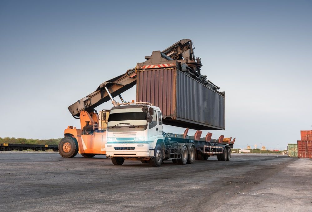 A Truck is Being Loaded With a Container in a Warehouse — Trucking Crane Trucks in Caloundra, QLD