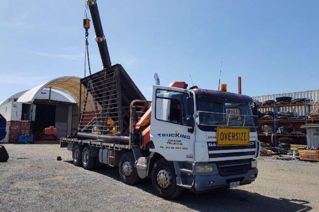 A Truck With a Yellow Sign on the Front That Says Overseas — Trucking Crane Trucks in Warana, QLD