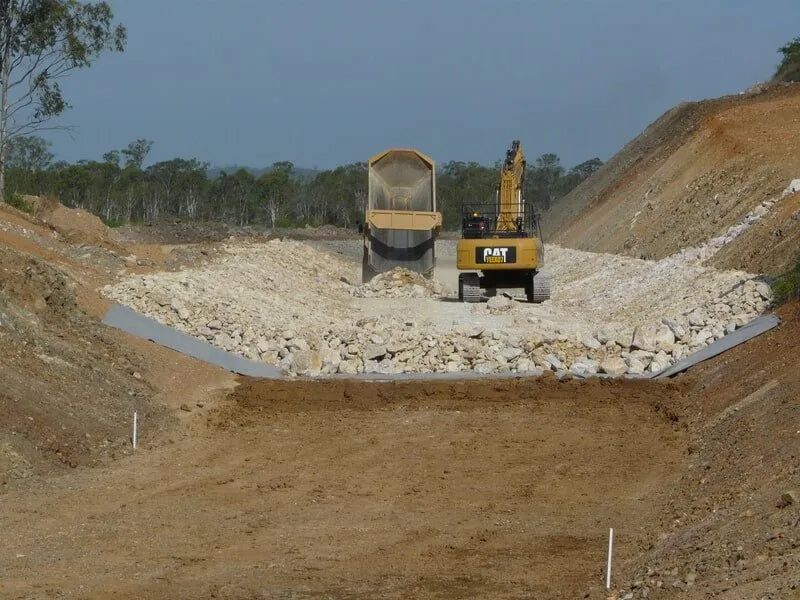 Dump Truck Is Unloading a Load of Rocks — Mike Barlow Earthmoving Pty Ltd in Rockhampton, QLD