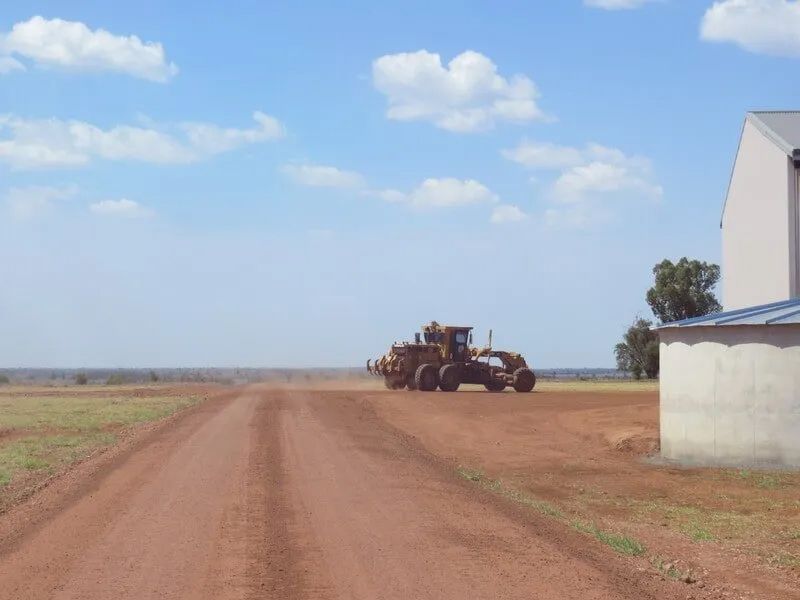 Bulldozer Driving On A Dirt Road For Construction — Mike Barlow Earthmoving Pty Ltd in Rockhampton, QLD