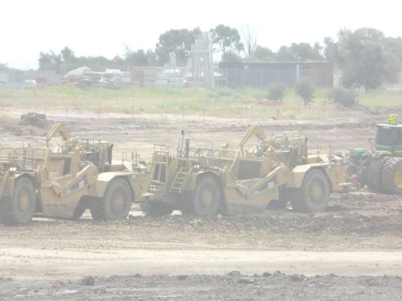 Three Excavators Working On A Dirt Field — Mike Barlow Earthmoving Pty Ltd in Rockhampton, QLD