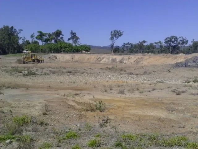 An Excavator Doing Field Cleaning — Mike Barlow Earthmoving Pty Ltd in Rockhampton, QLD