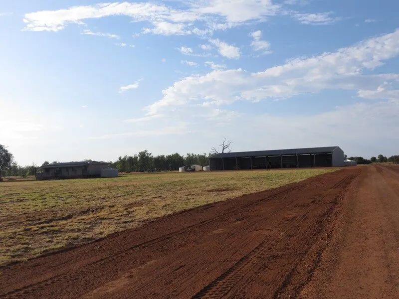 A Dirt Road Going Through A Field With A Shed In The Background — Mike Barlow Earthmoving Pty Ltd in Rockhampton, QLD