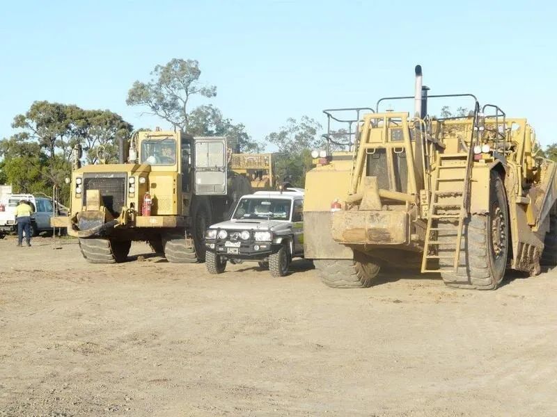 Two Big Excavator And Pickup Truck Parked In Between — Mike Barlow Earthmoving Pty Ltd in Rockhampton, QLD