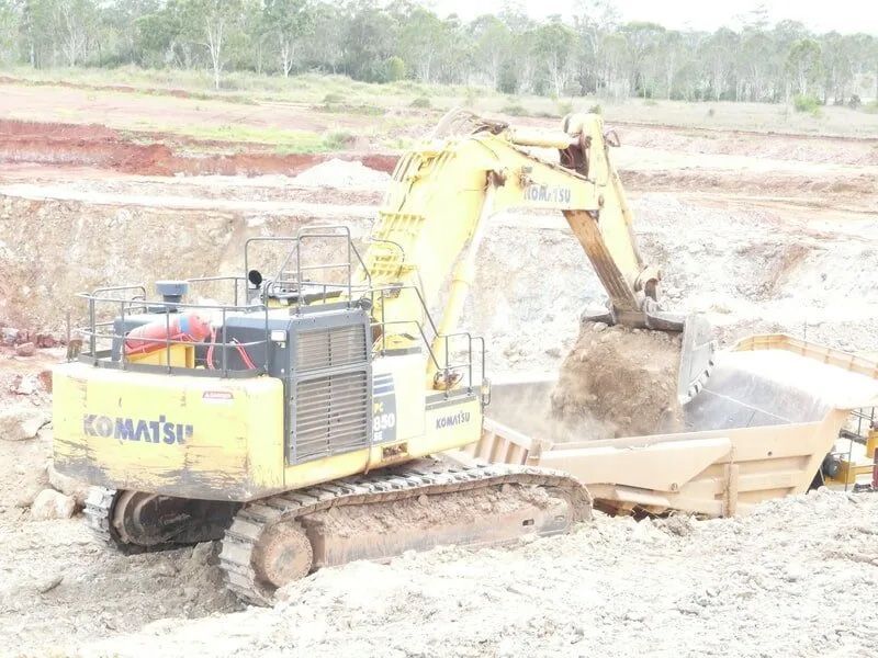 Excavator Loading A Soil In A Waste Bin — Mike Barlow Earthmoving Pty Ltd in Rockhampton, QLD