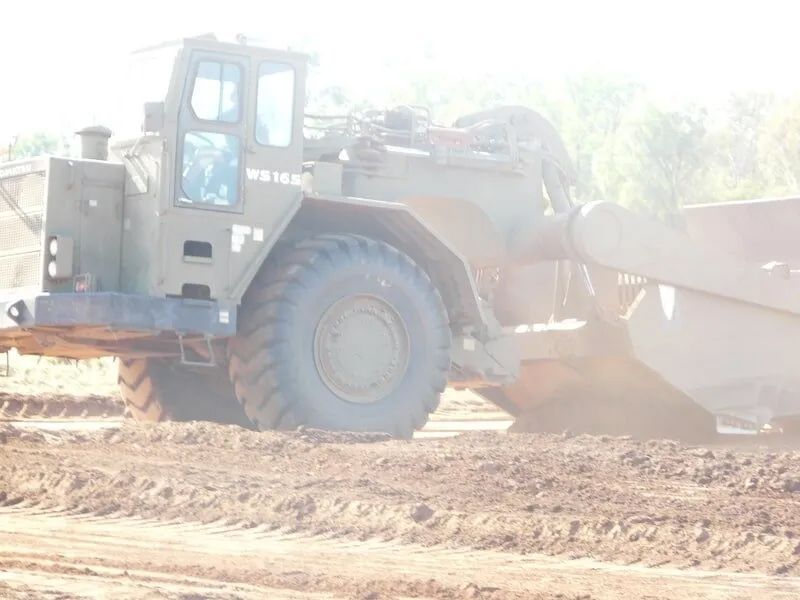 Close Up Excavator Working On Dirt Field — Mike Barlow Earthmoving Pty Ltd in Rockhampton, QLD