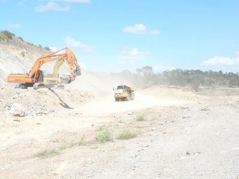 Excavator Loading Rocks on a Truck — Mike Barlow Earthmoving Pty Ltd in Rockhampton, QLD