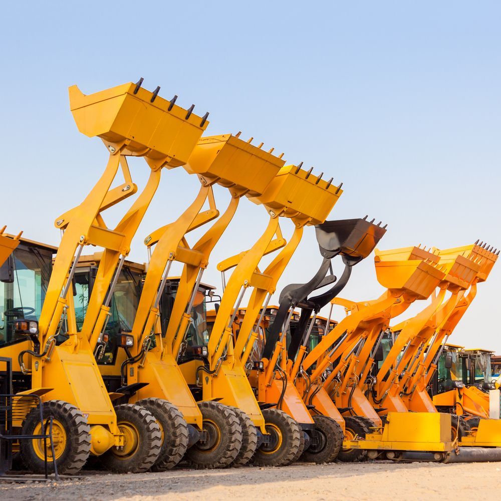 Row of Yellow Front Loaders Parked Outdoors Under a Clear Blue Sky — Mike Barlow Earthmoving Pty Ltd in Rockhampton, QLD