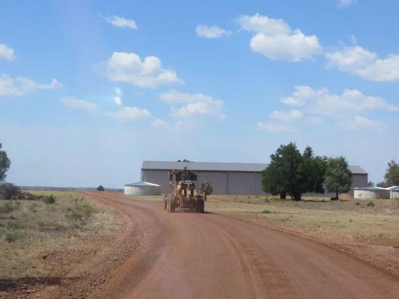 Excavator Driving On The Middle Of The Dirt Road — Mike Barlow Earthmoving Pty Ltd in Rockhampton, QLD