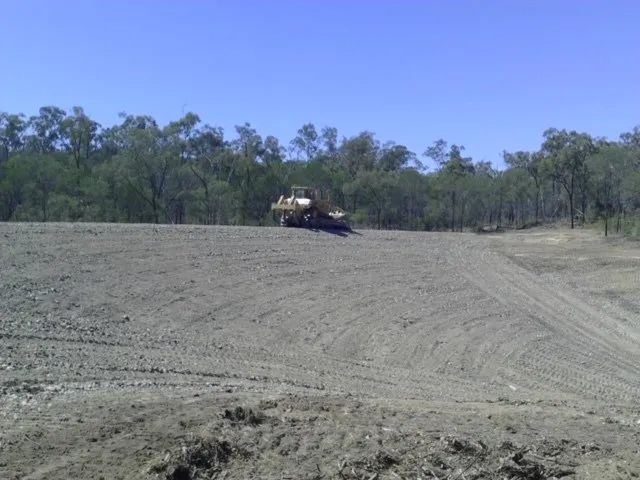 Excavator Rolling On The Dam Site — Mike Barlow Earthmoving Pty Ltd in Rockhampton, QLD