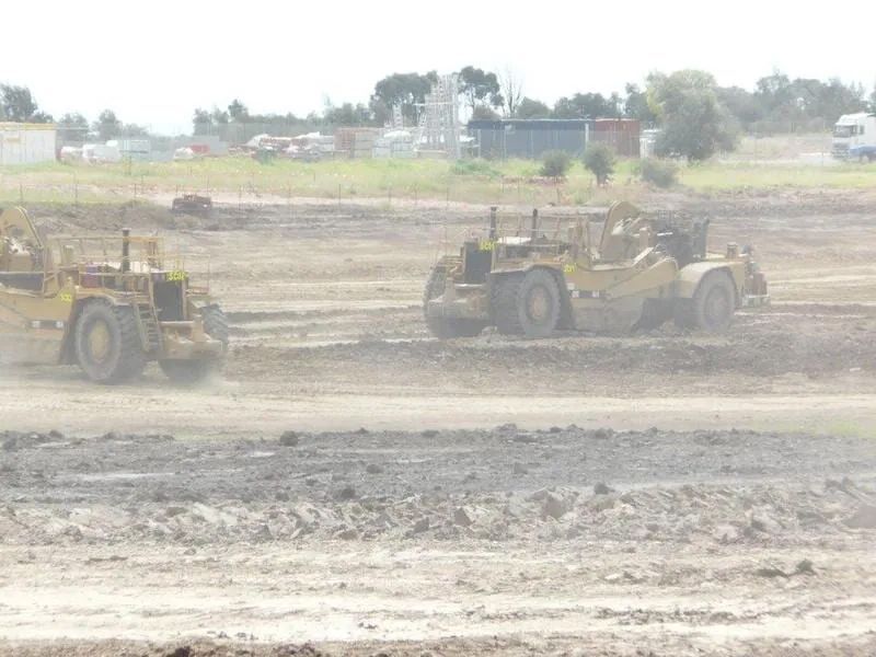 Two Excavator Are Working On A Dirt Field — Mike Barlow Earthmoving Pty Ltd in Rockhampton, QLD