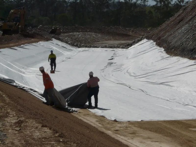 Three People Working On The Dam Site — Mike Barlow Earthmoving Pty Ltd in Rockhampton, QLD