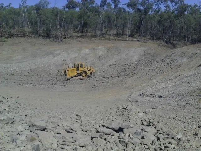 One Yellow Excavator Cleaning Land — Mike Barlow Earthmoving Pty Ltd in Rockhampton, QLD