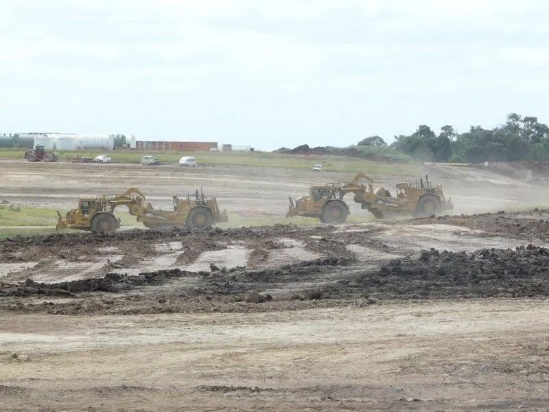 Excavator Operating in Muddy Field — Mike Barlow Earthmoving Pty Ltd in Rockhampton, QLD