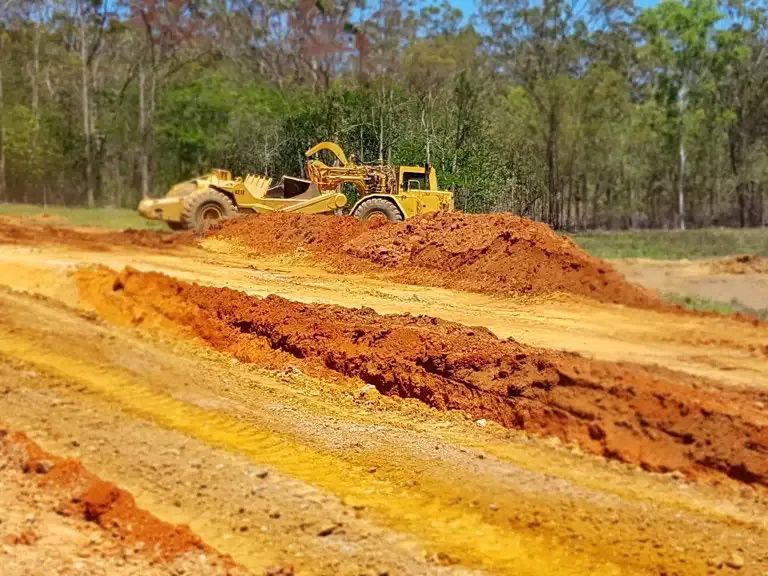 Bulldozer Is Moving Dirt On A Dirt Road — Mike Barlow Earthmoving Pty Ltd in Rockhampton, QLD