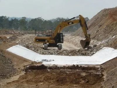 A Yellow Excavator Is Clearing Dirt For Road Construction — Mike Barlow Earthmoving Pty Ltd in Yeppoon, QLD