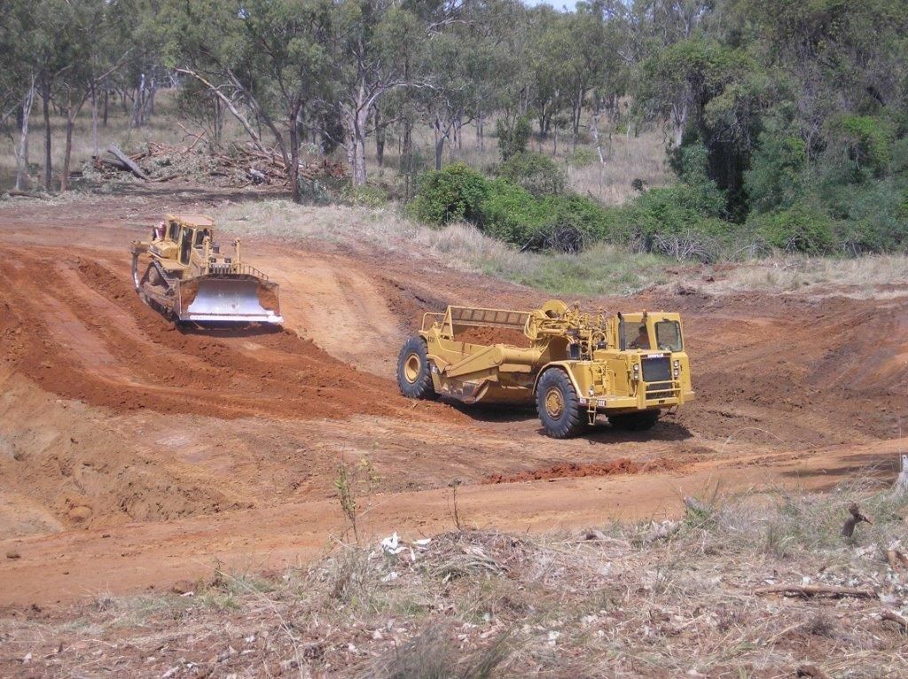 A Large Yellow Tractor Is Being Transported on A Trailer — Mike Barlow Earthmoving Pty Ltd in Rockhampton, QLD