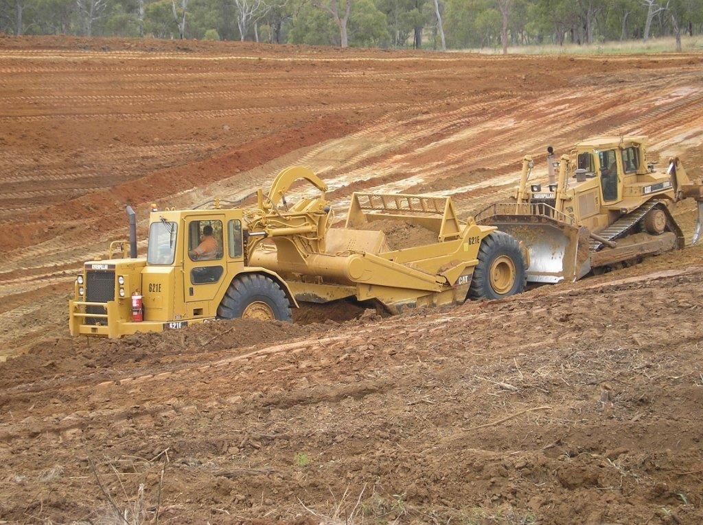 A Bulldozer and A Tractor Are Working on A Dirt Road — Mike Barlow Earthmoving Pty Ltd in Rockhampton, QLD
