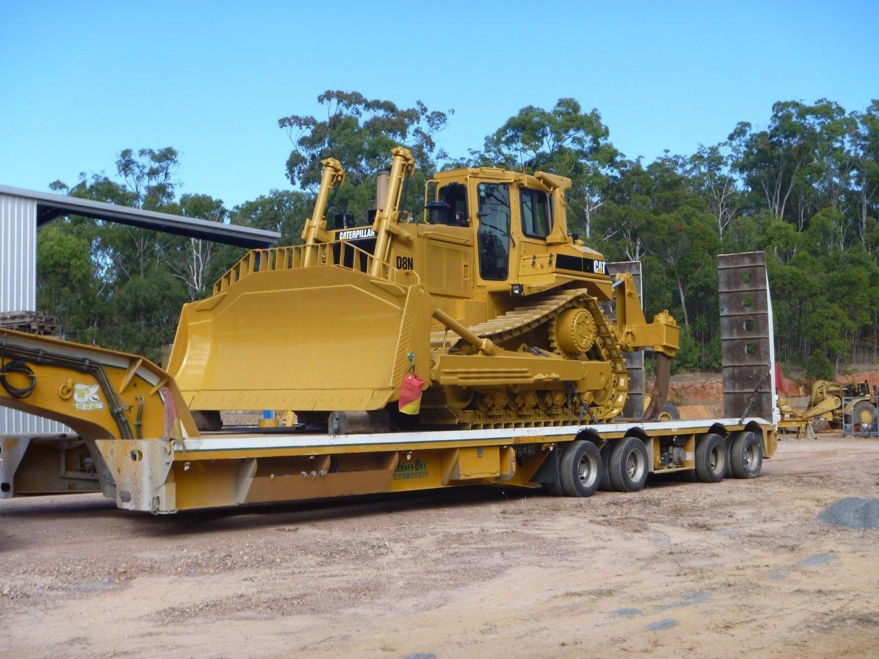 A Large Excavator Is Digging in The Dirt on A Construction Site — Mike Barlow Earthmoving Pty Ltd in Rockhampton, QLD