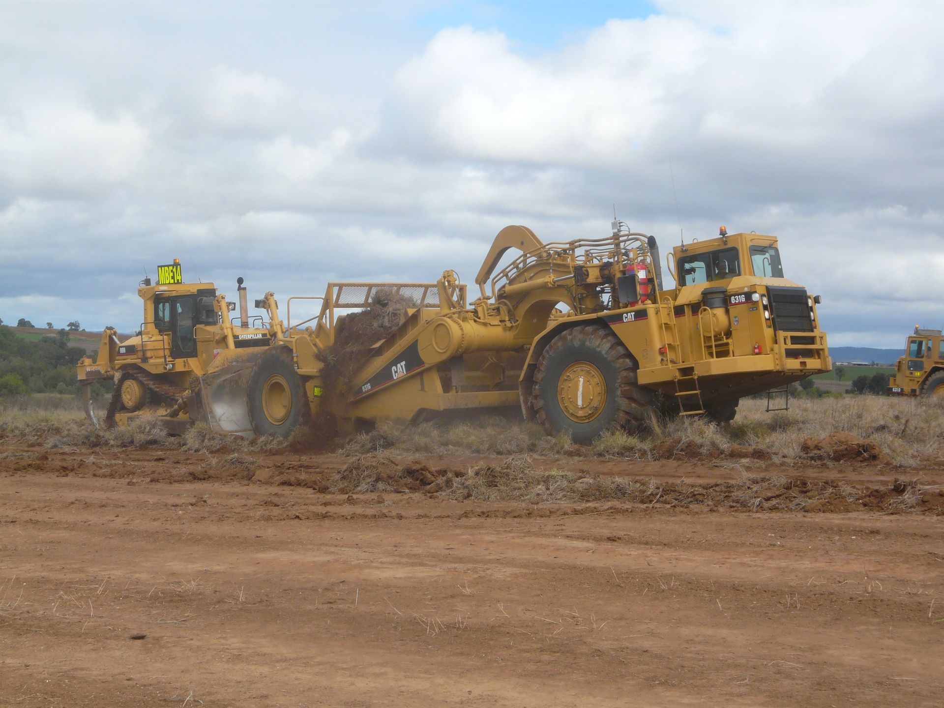 A Dump Truck Is Dumping Dirt Into a Field — Mike Barlow Earthmoving Pty Ltd in Central Highlands, QLD