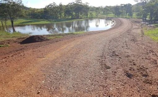 A Dirt Road With A Pond In The Middle Of It — Mike Barlow Earthmoving Pty Ltd in Rockhampton, QLD