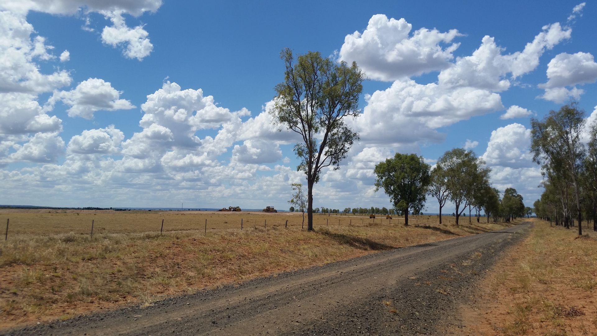 A Yellow Excavator Is Working on A Pile of Rocks — Mike Barlow Earthmoving Pty Ltd in Yeppoon, QLD
