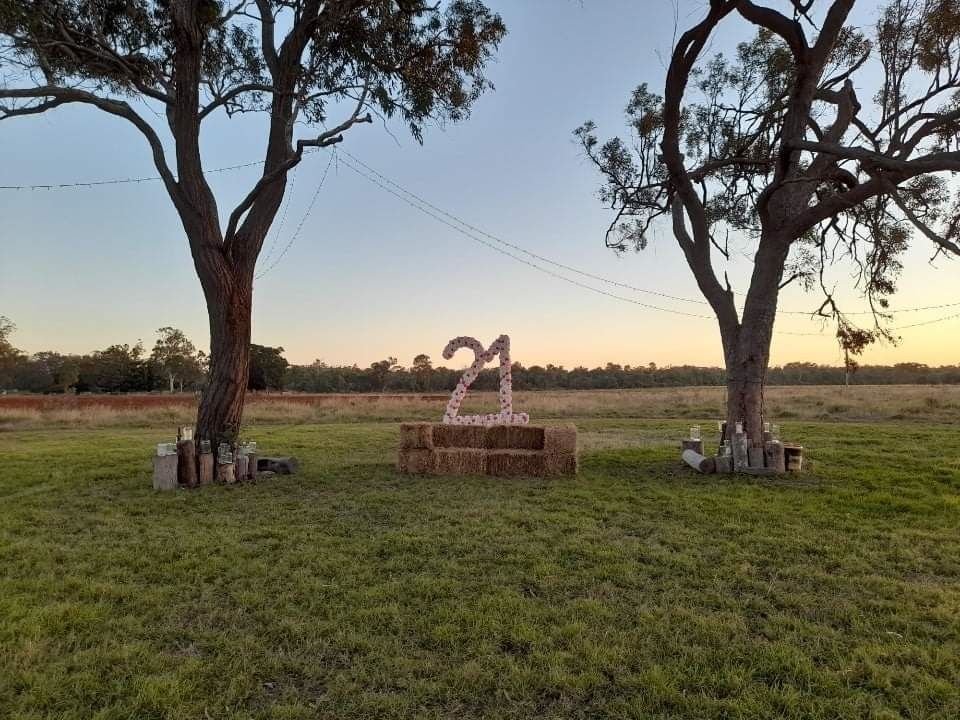 A Yellow Crane Is Driving Down a Dirt Road Next to A Tractor — Mike Barlow Earthmoving Pty Ltd in Rockhampton, QLD