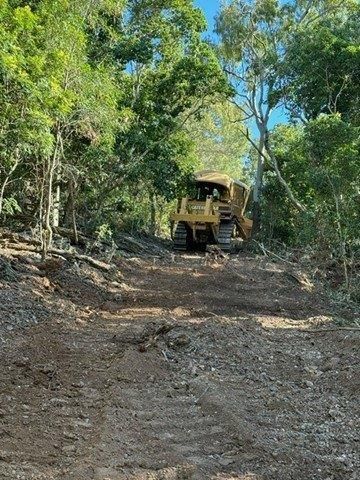 Two Bulldozers Are Moving Dirt in A Field — Mike Barlow Earthmoving Pty Ltd in Rockhampton, QLD