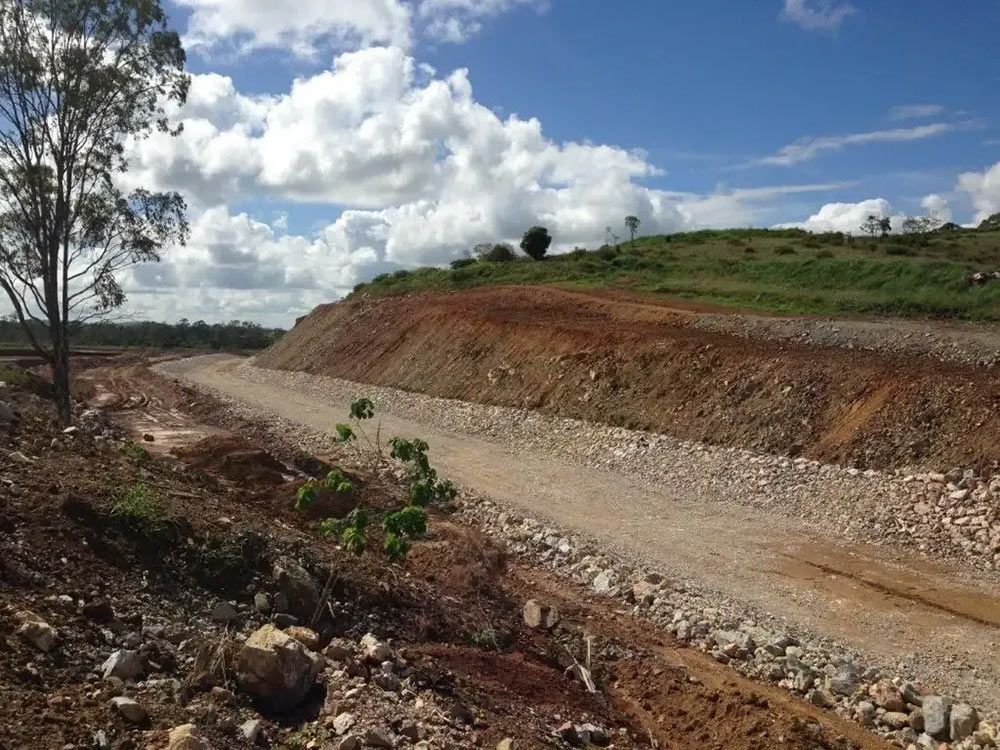 A Dirt Road with A Hill in The Background — Mike Barlow Earthmoving Pty Ltd in Rockhampton, QLD