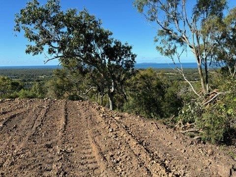 A Bulldozer Is Driving Down a Dirt Road — Mike Barlow Earthmoving Pty Ltd in Rockhampton, QLD