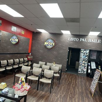 A barbershop interior with chairs, brick walls, and a sign that reads 