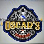 Logo for Oscar's Barbershop, featuring a barber pole, scissors, and text in yellow and white on a blue and black background. Includes the phrase 