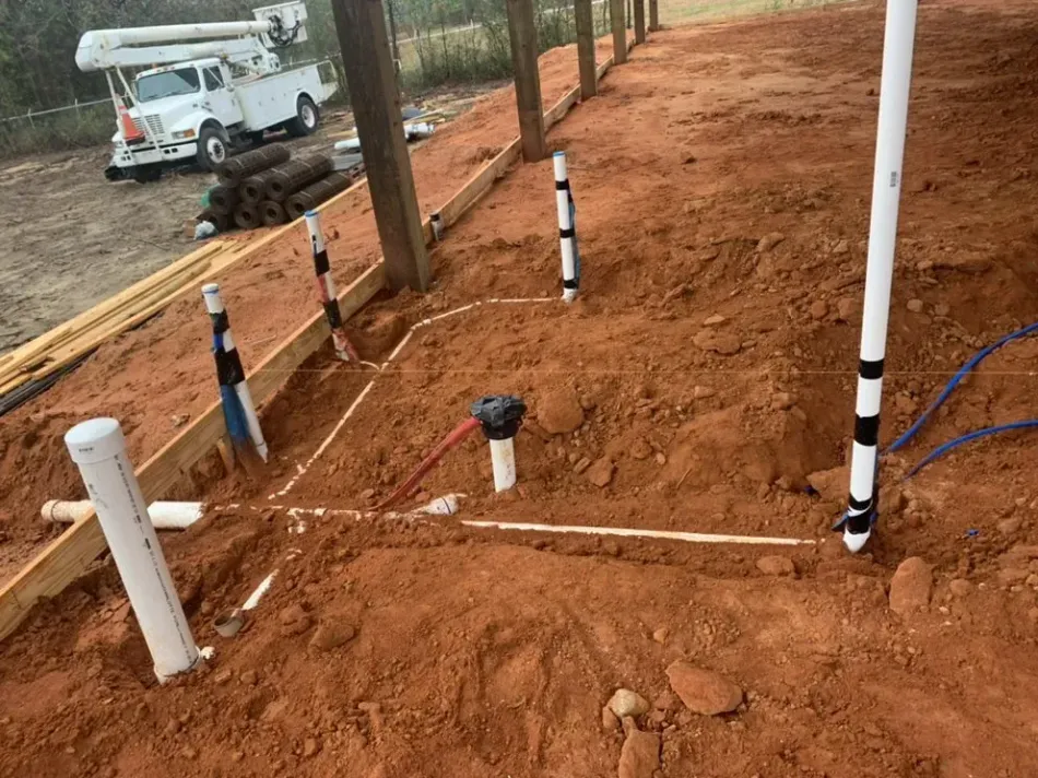 A white truck is parked on the side of a dirt road.