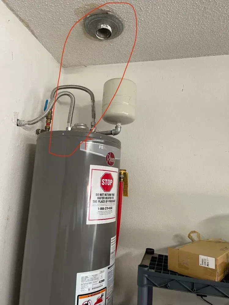 A water heater is hanging from the ceiling in a room.