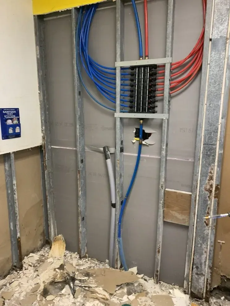 A wall with a bunch of wires hanging from it