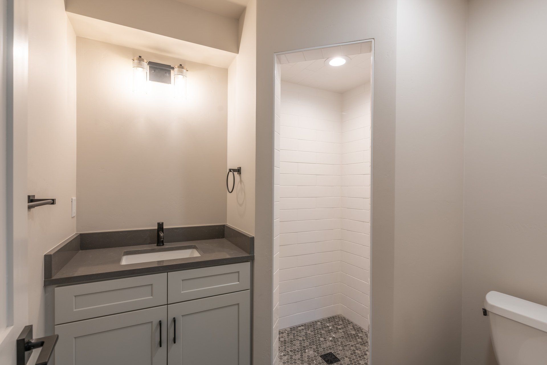 A bathroom with a sink , toilet and shower.