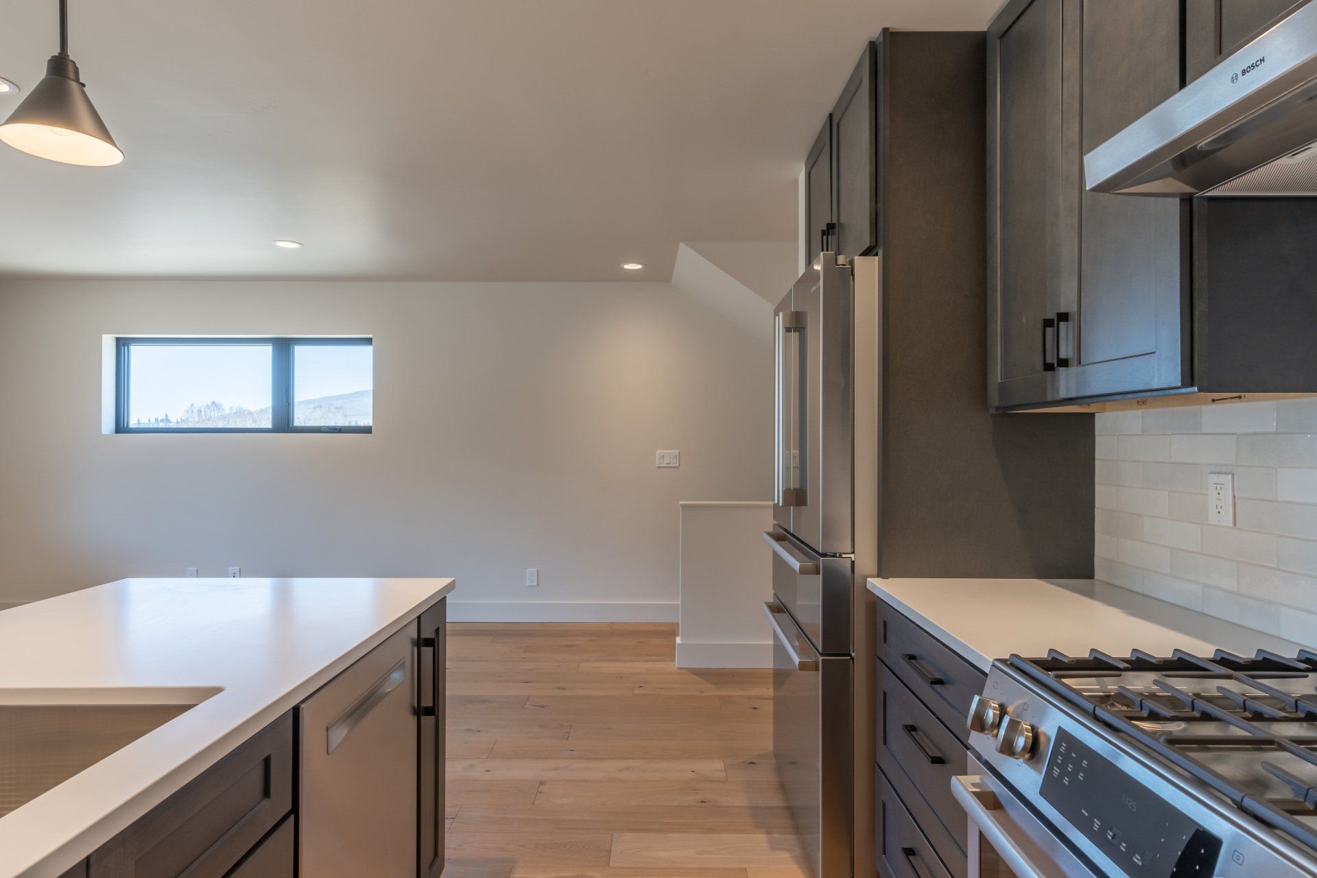 A kitchen with a stove , refrigerator , dishwasher and sink.