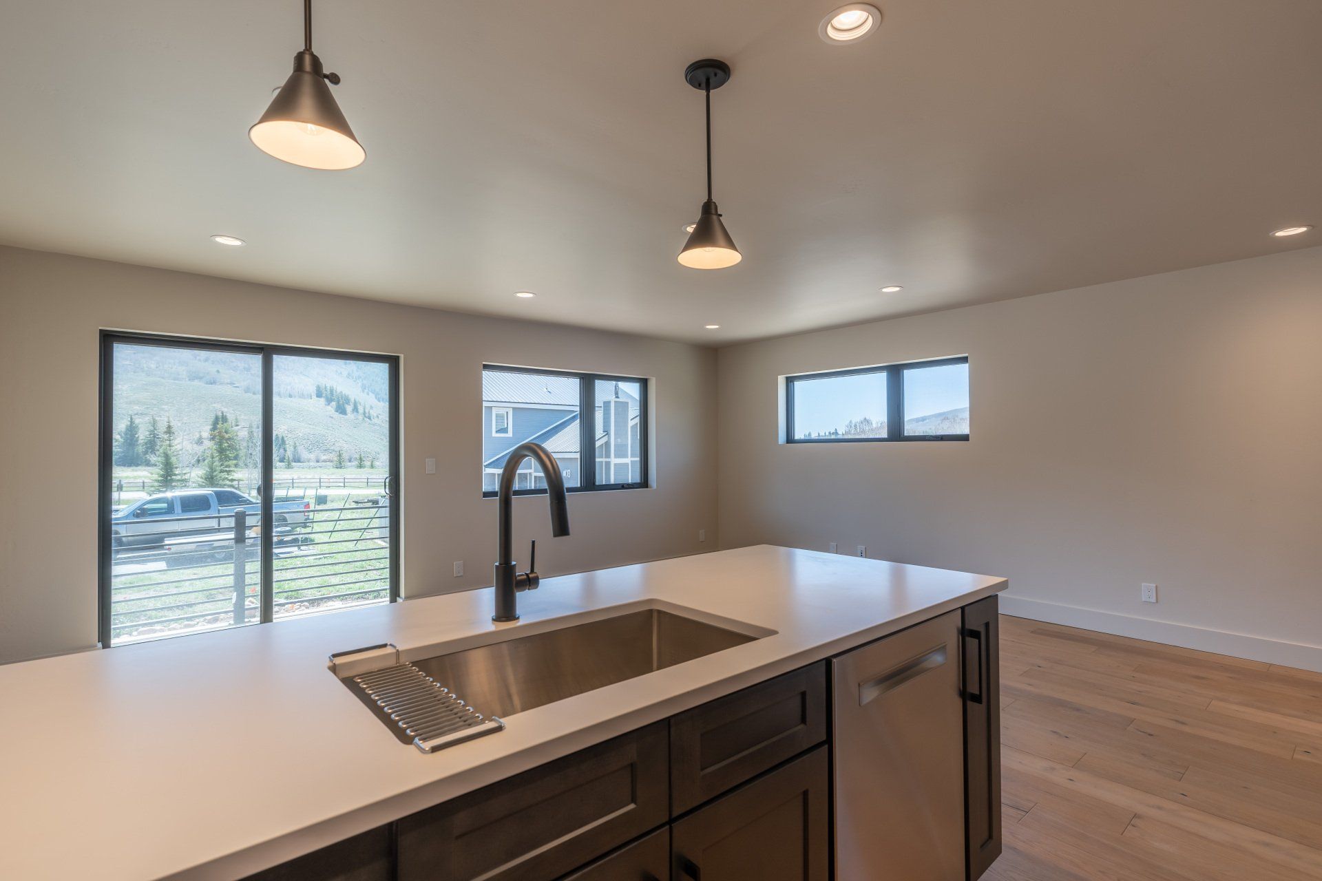 A kitchen with a sink , cabinets , and sliding glass doors.