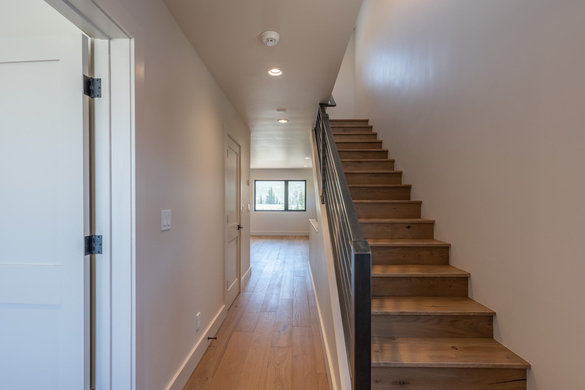 A hallway with wooden stairs leading up to the second floor of a house.