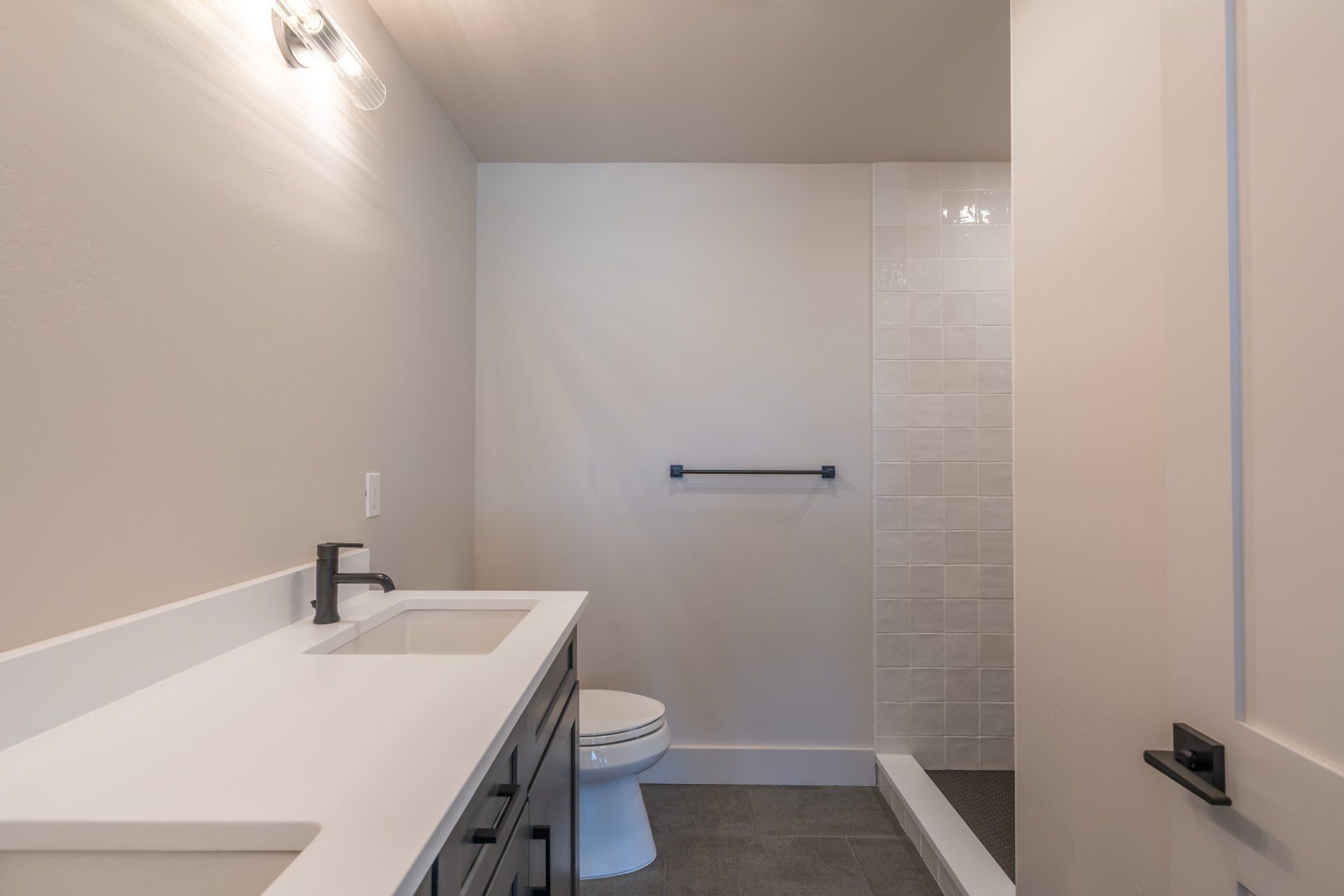 A bathroom with a toilet , sink , and walk in shower.