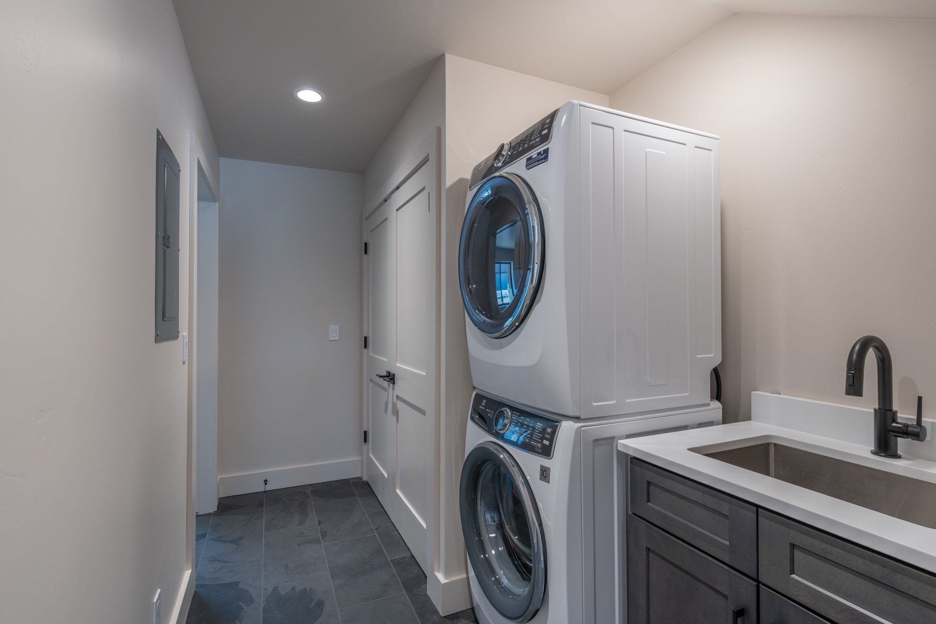 A laundry room with a washer and dryer stacked on top of each other.