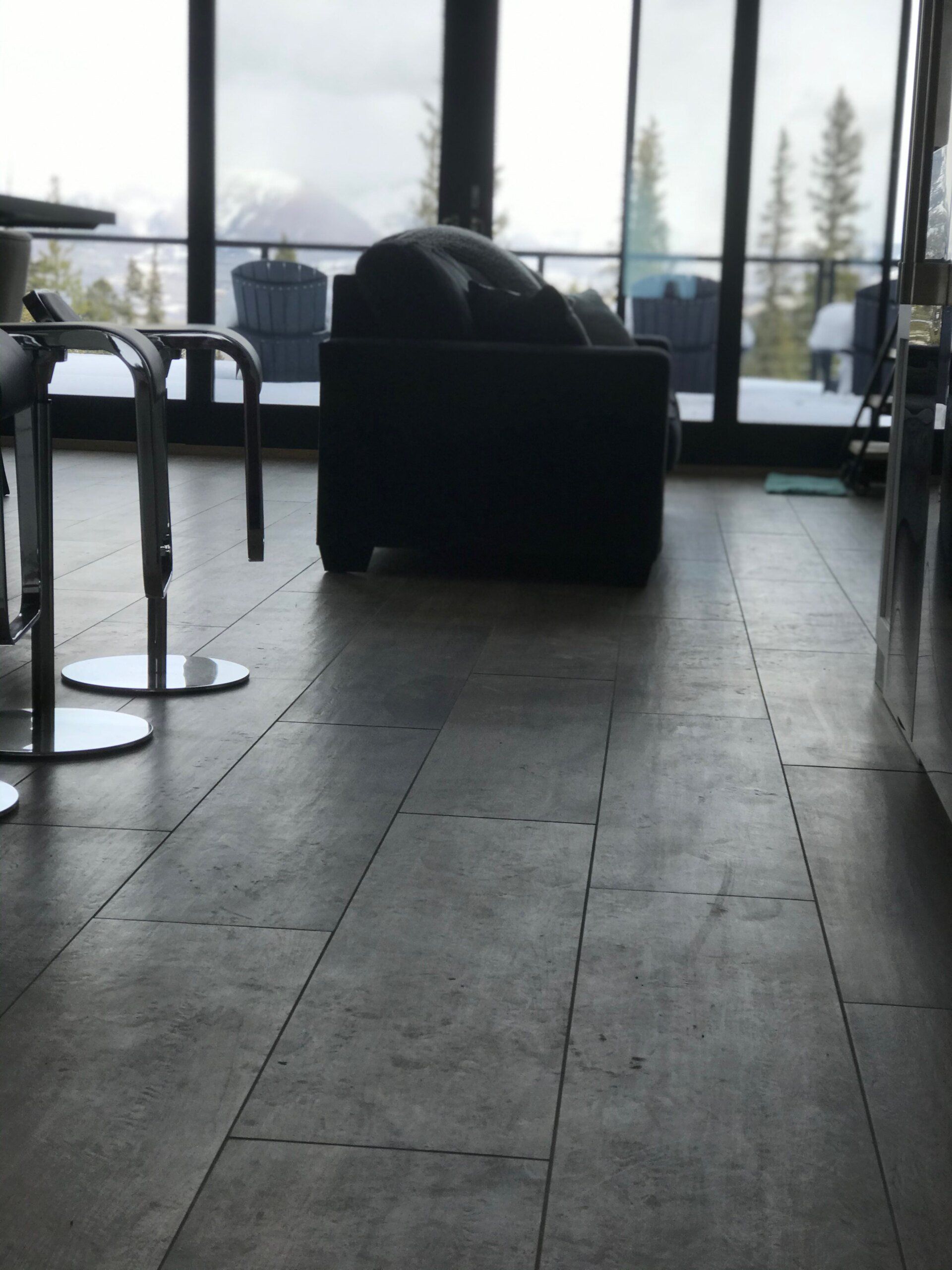 A living room with a couch and chairs and a large window