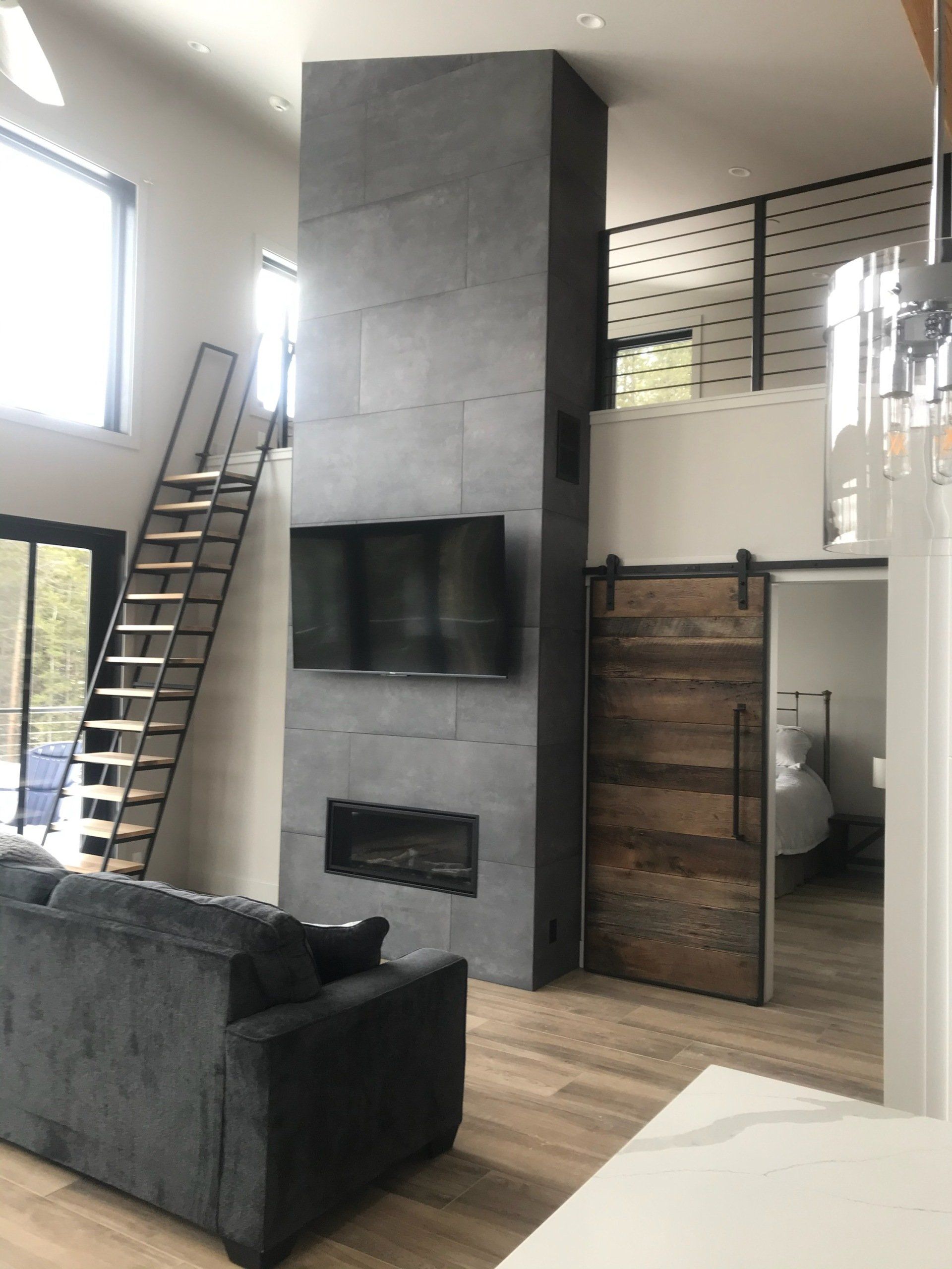 A living room with a sliding barn door and a staircase