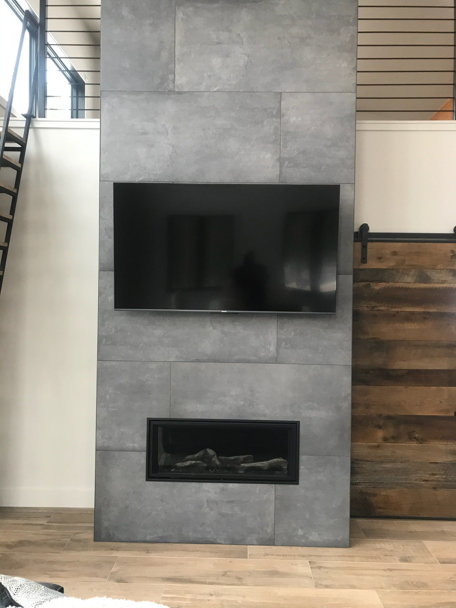 A flat screen tv mounted on a wall above a fireplace