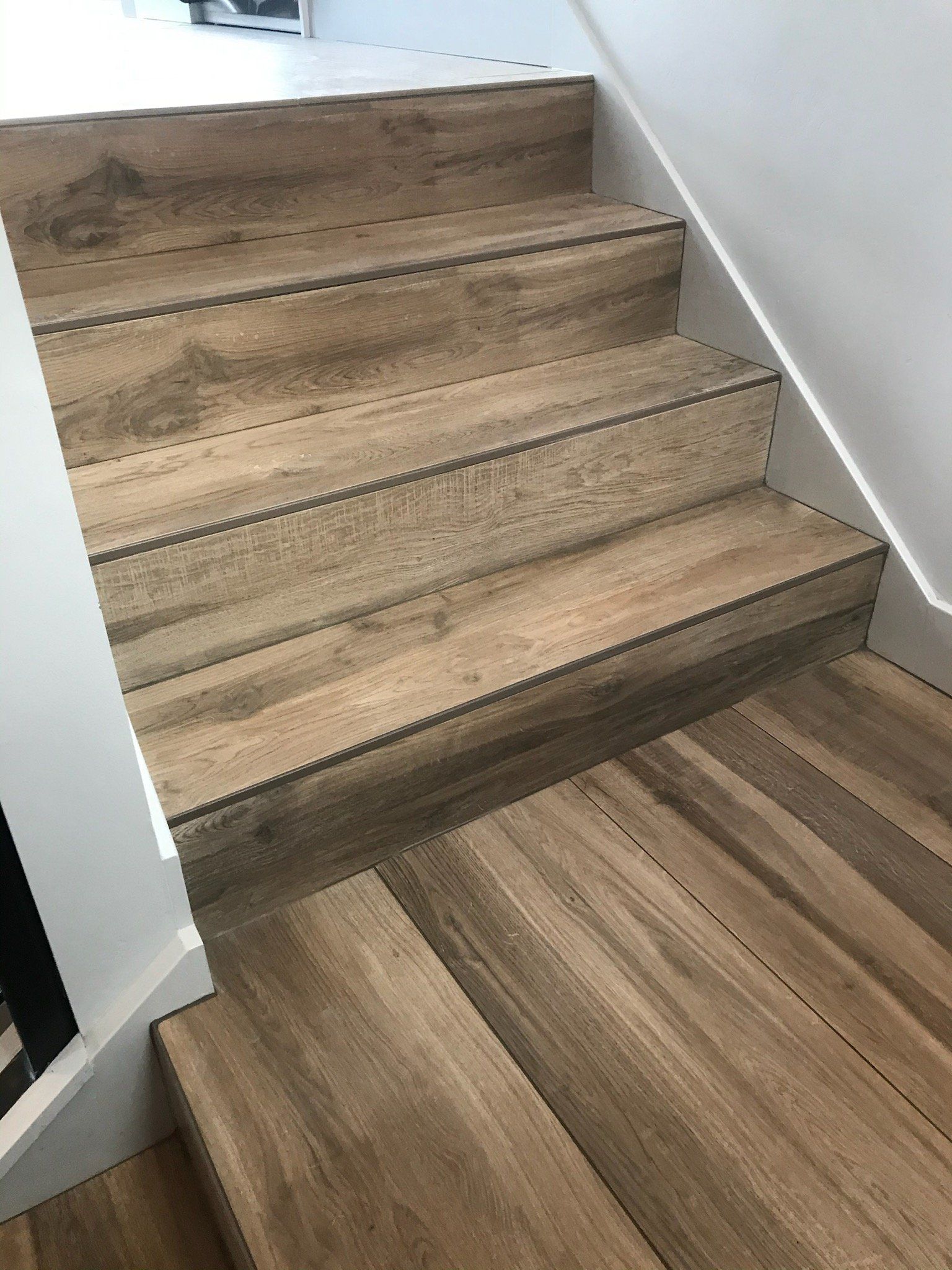 A close up of a wooden staircase with a white railing.