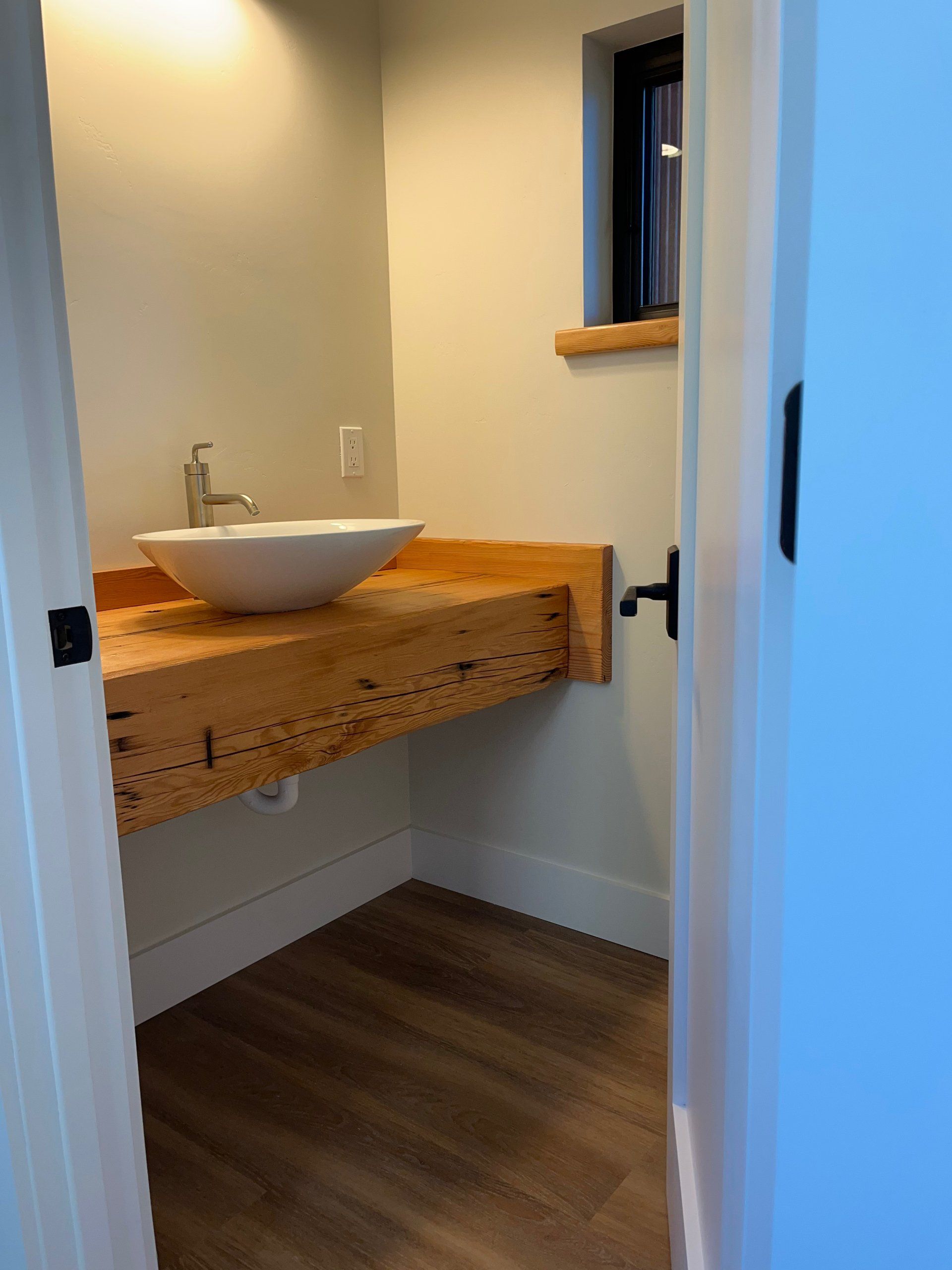 A bathroom with a wooden counter top and a sink.