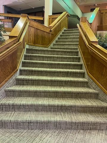 A set of stairs with a wooden railing in a building.