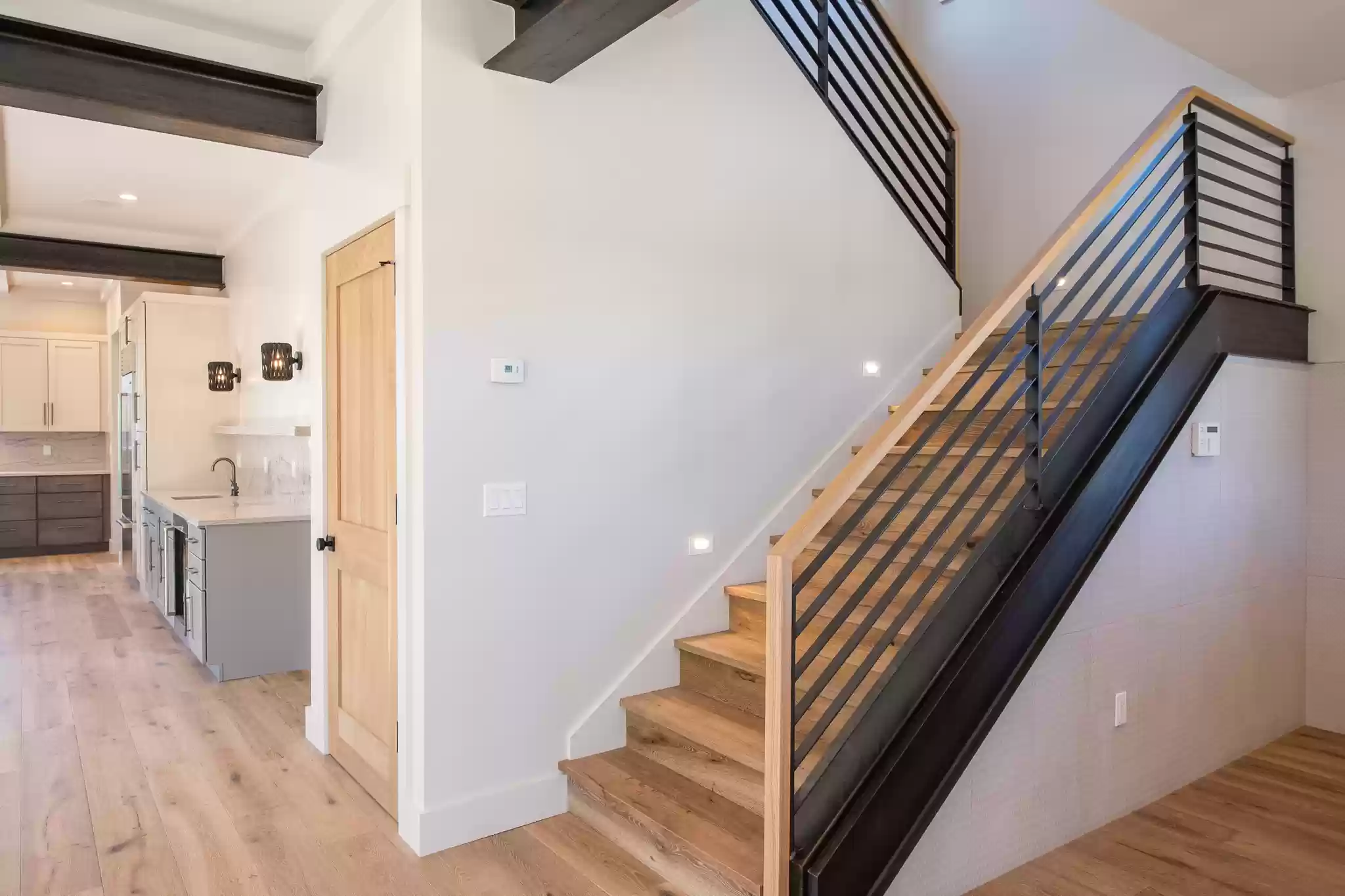A wooden staircase with a metal railing in a house.