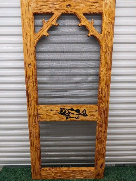 A wooden screen door with a fish carved into it